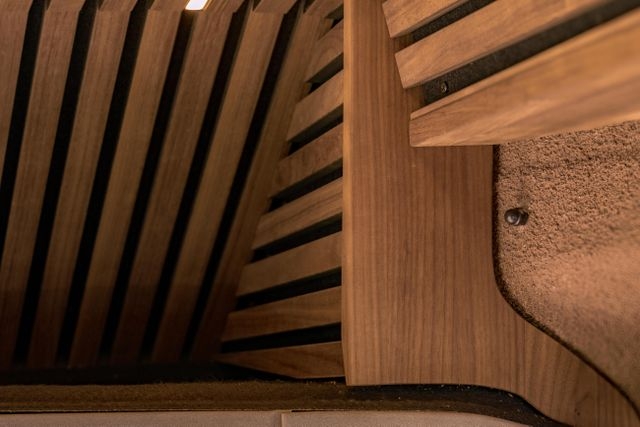 Aufwendige Schreinerarbeit im Camper Van von Cocoon Vans. Die Deckenverkleidung aus amerikanischen Nussbaum wurde zum sichtbaren Sprühkork aufwendig abgeschlossen